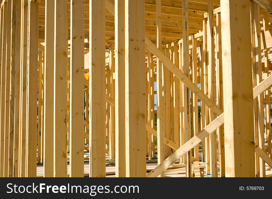 A new home being built with wood, trusses, supports and a foundation. A new home being built with wood, trusses, supports and a foundation.