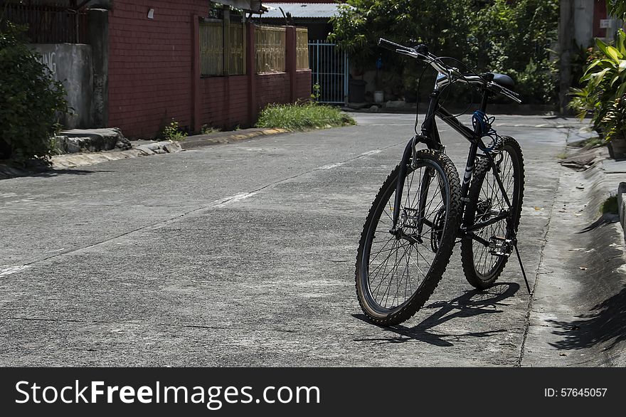 A bicycle parked beside the house in a certain subdivision. A bicycle parked beside the house in a certain subdivision.