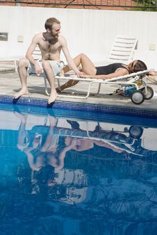 Man And Woman Lounging Beside A Pool - Vertical Stock Images Man And Woman Lounging Beside A Pool - Vertical Stock Images
