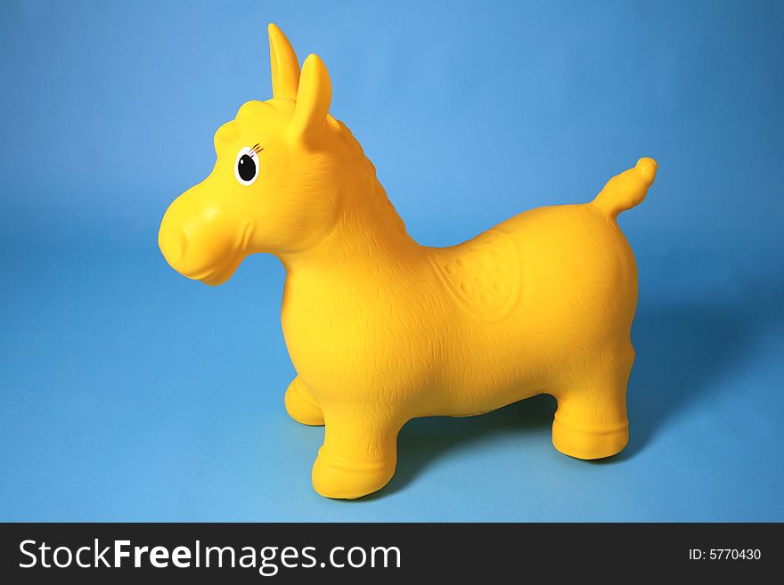 Yellow gymnastic pony on blue background