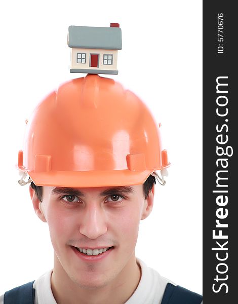 Muscular young man in a builder uniform with house model. Muscular young man in a builder uniform with house model.