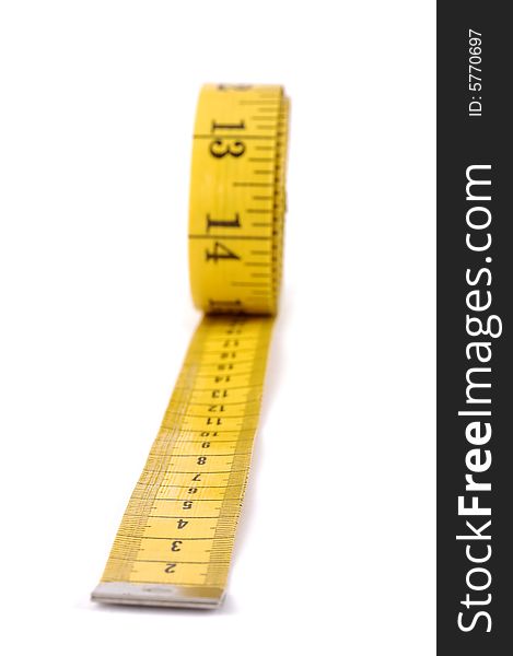 A yellow measuring tape with selective focus. A yellow measuring tape with selective focus