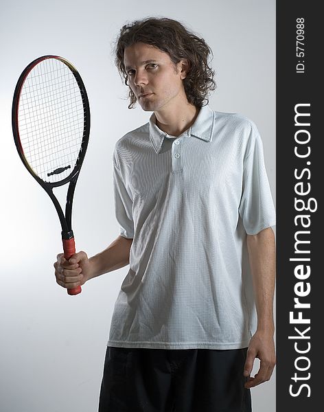 A man, wearing a white polo, holds a tennis racket, looking angrily. Vertically framed shot. A man, wearing a white polo, holds a tennis racket, looking angrily. Vertically framed shot.