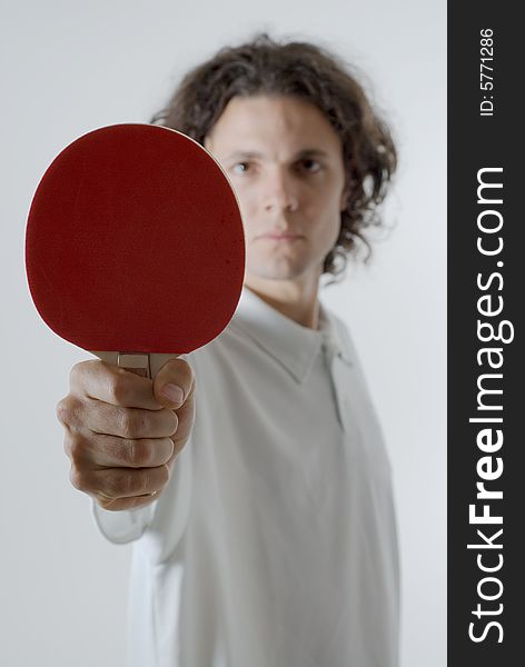 Man holding a ping-pong paddle stares ahead with a serious look on his face. Vertically framed photograph. Man holding a ping-pong paddle stares ahead with a serious look on his face. Vertically framed photograph.