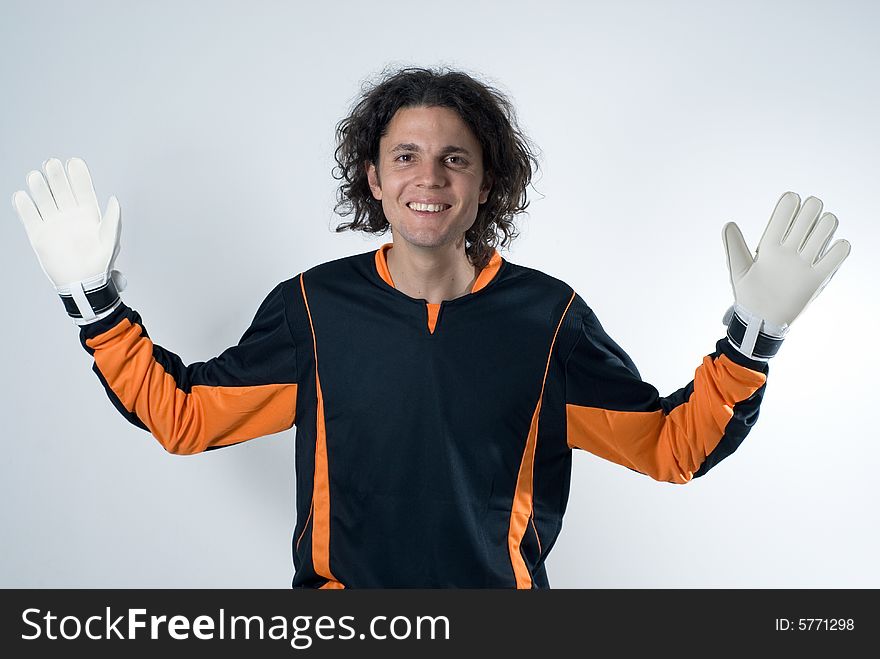 A smiling goalie with his hands stretched out defensively.  He is staring at the camera, and is wearing white gloves. Horizontally framed shot. A smiling goalie with his hands stretched out defensively.  He is staring at the camera, and is wearing white gloves. Horizontally framed shot.