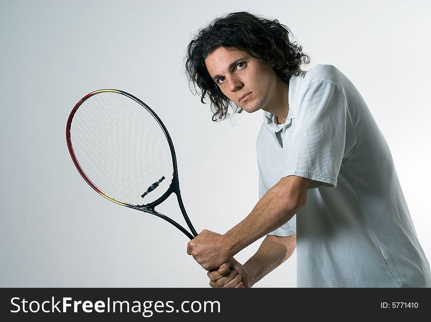 Man with a serious look on his face holds a tennis racket. Horizontally framed photograph. Man with a serious look on his face holds a tennis racket. Horizontally framed photograph