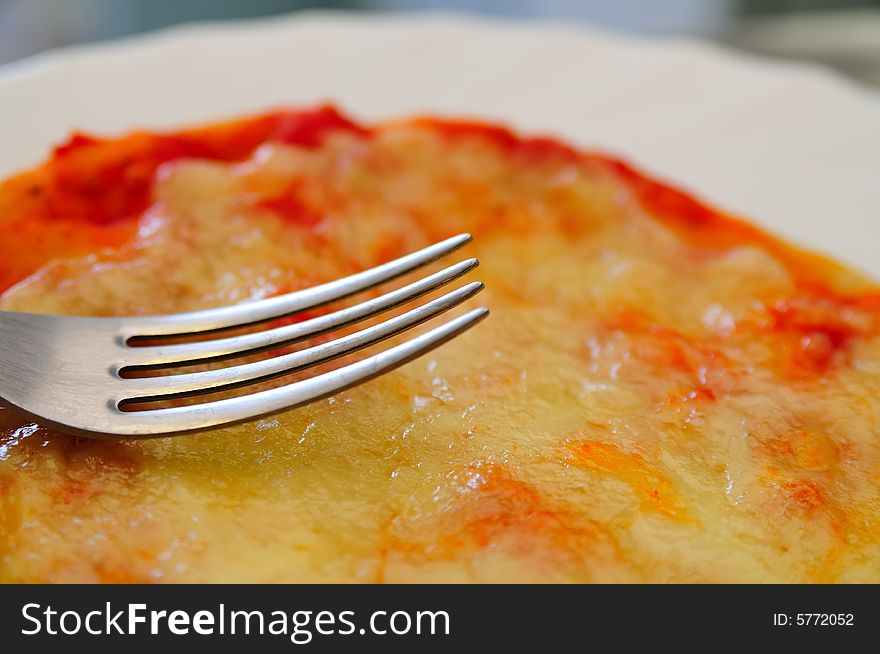 Close shot about a little tomato and mozzarella cheese pizza, with a fork. Close shot about a little tomato and mozzarella cheese pizza, with a fork.