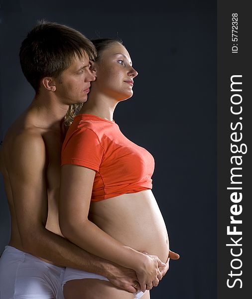 The man and woman with child standing against black background. The man and woman with child standing against black background