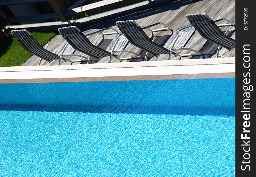 A particular shot of a pool and deckchairs on the solarium. A particular shot of a pool and deckchairs on the solarium