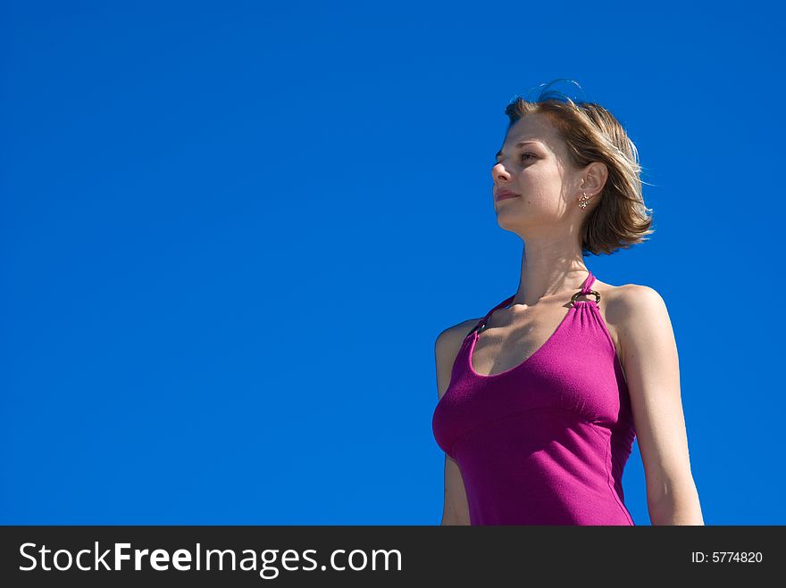 Young woman in purple dress is looking somewhere. Young woman in purple dress is looking somewhere