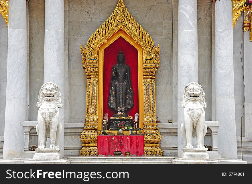 Thailand, the Wat Benchamabophit or the Marble temple in the city of Bangkok constructed in 1900 is faced with white Carrara marble. View of an outdoor standing Buddha. Thailand, the Wat Benchamabophit or the Marble temple in the city of Bangkok constructed in 1900 is faced with white Carrara marble. View of an outdoor standing Buddha