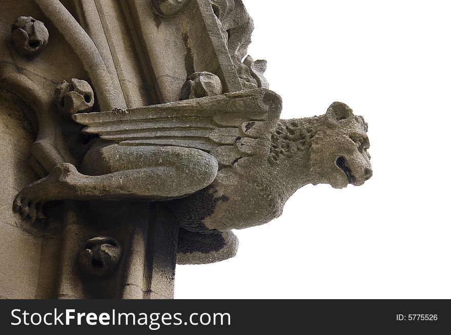 A gargoyle of a winged creature projects from the side of a church in Oxford, England. A gargoyle of a winged creature projects from the side of a church in Oxford, England.