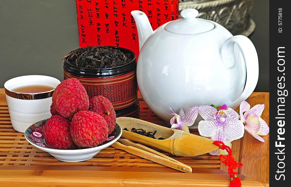 Asian pottery tea set with chinese tea and litchees