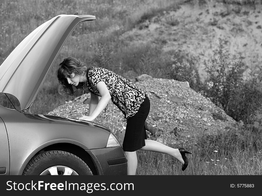 A girl trying to repair the car