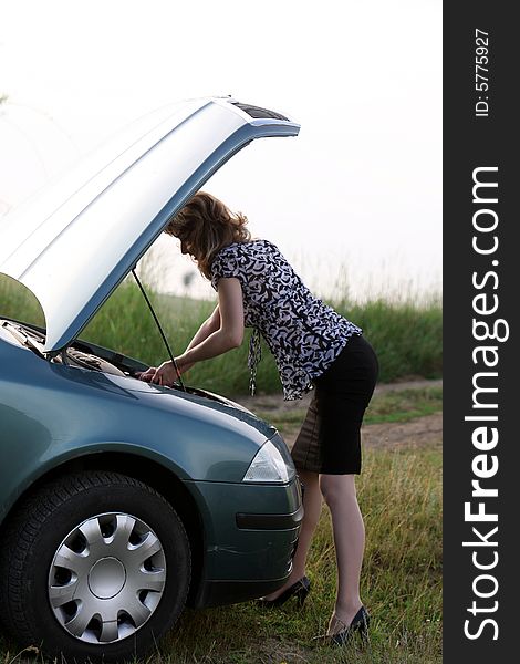 A sexy girl trying to repair the car