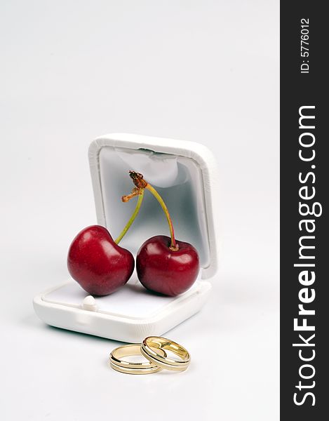 Wedding rings and  cherry's on a nice background. Wedding rings and  cherry's on a nice background