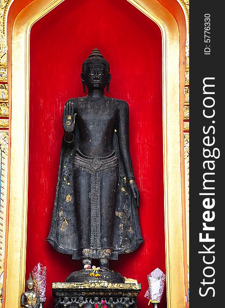 Thailand, the Wat Benchamabophit or the Marble temple in the city of Bangkok constructed in 1900 is faced with white Carrara marble.View of an outsider standing Buddha inside a red niche. Thailand, the Wat Benchamabophit or the Marble temple in the city of Bangkok constructed in 1900 is faced with white Carrara marble.View of an outsider standing Buddha inside a red niche