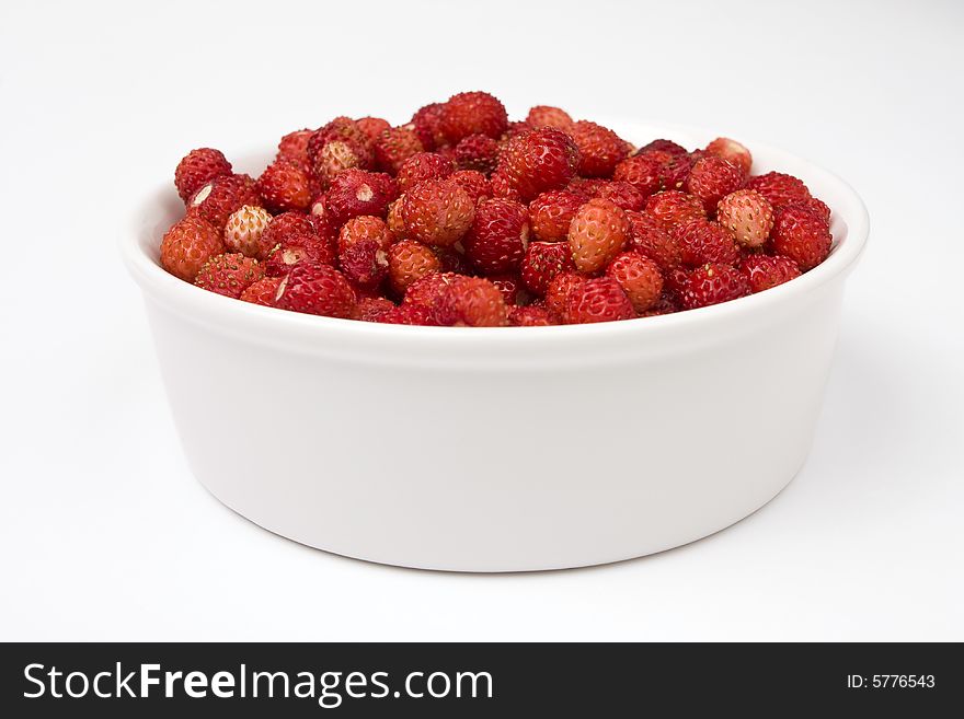 A close-up of a bowl of fresh wild strawberry
