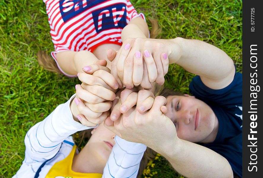 Three Friends Lay On A Grass