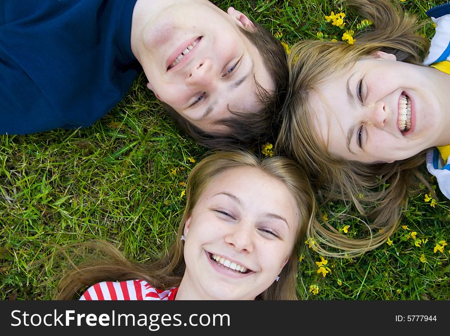 Three Friends Lay On A Grass