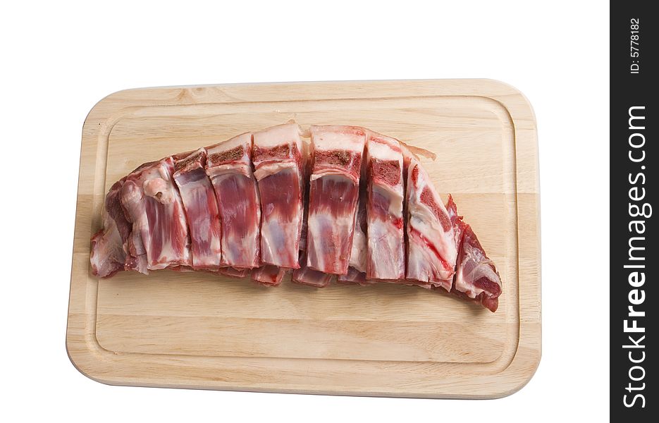 Mutton-chop on wooden board on white ground