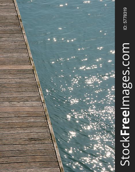 Timber jetty with glistening blue water