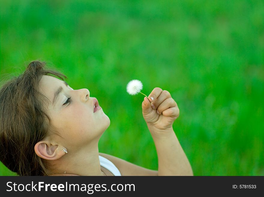 Girl with dandelion on meadow