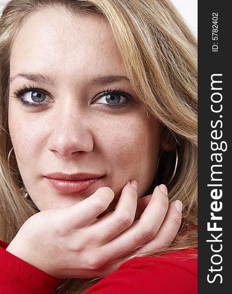 Beautiful mature blonde woman wearing a red top with her hand at her chin. Beautiful mature blonde woman wearing a red top with her hand at her chin