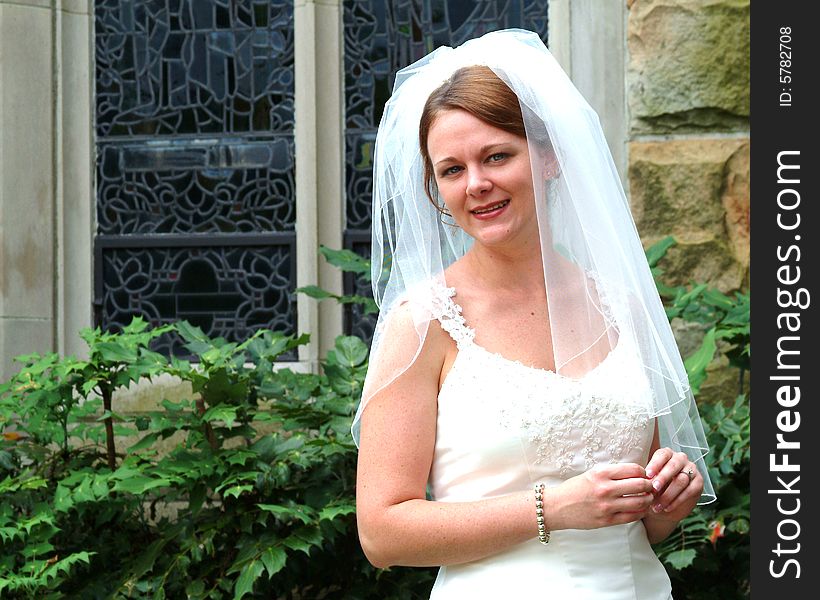 View of bride outside near stained glass window
