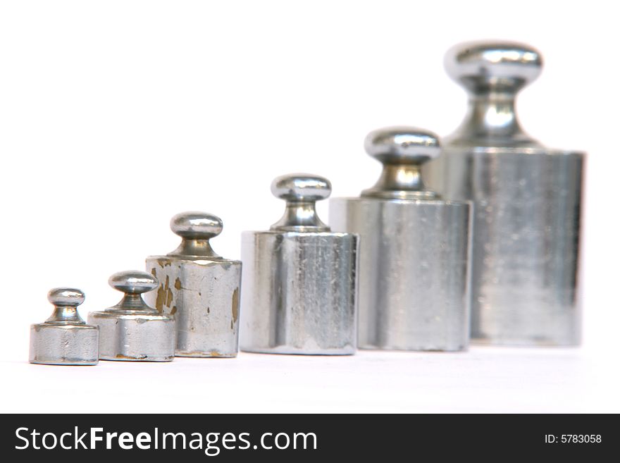 Different weight units in a row focus on the small one isolated on white background. Different weight units in a row focus on the small one isolated on white background