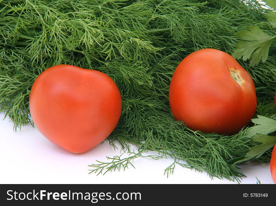 Two tomatos with dill and parsley background food and vegetables