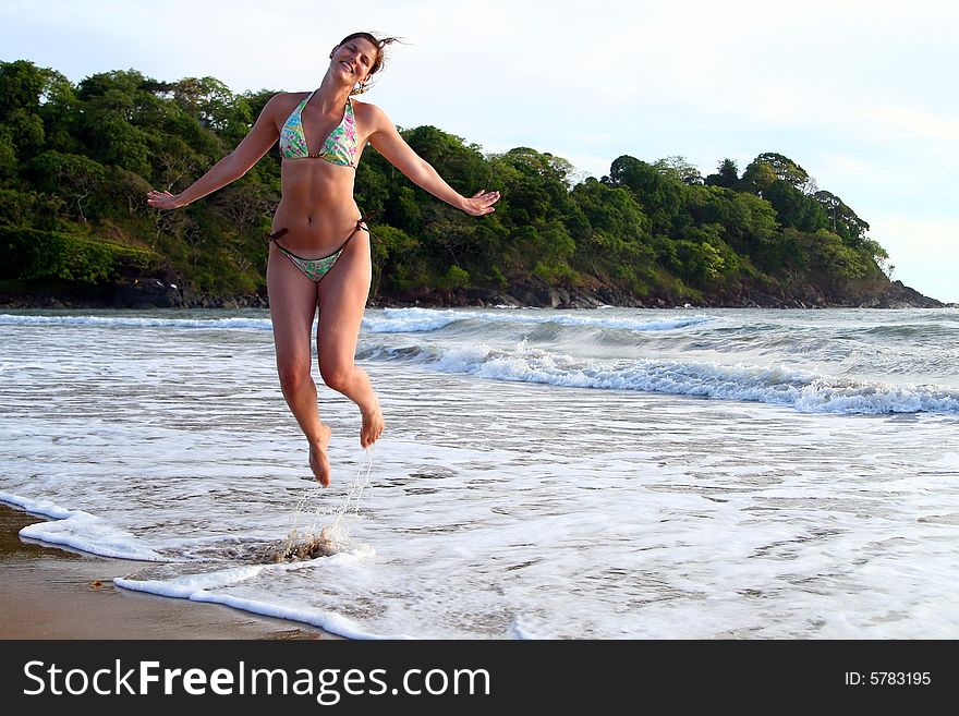 Young woman is jumping happily on the beach. Ideal shot for vacation or summer. Young woman is jumping happily on the beach. Ideal shot for vacation or summer.