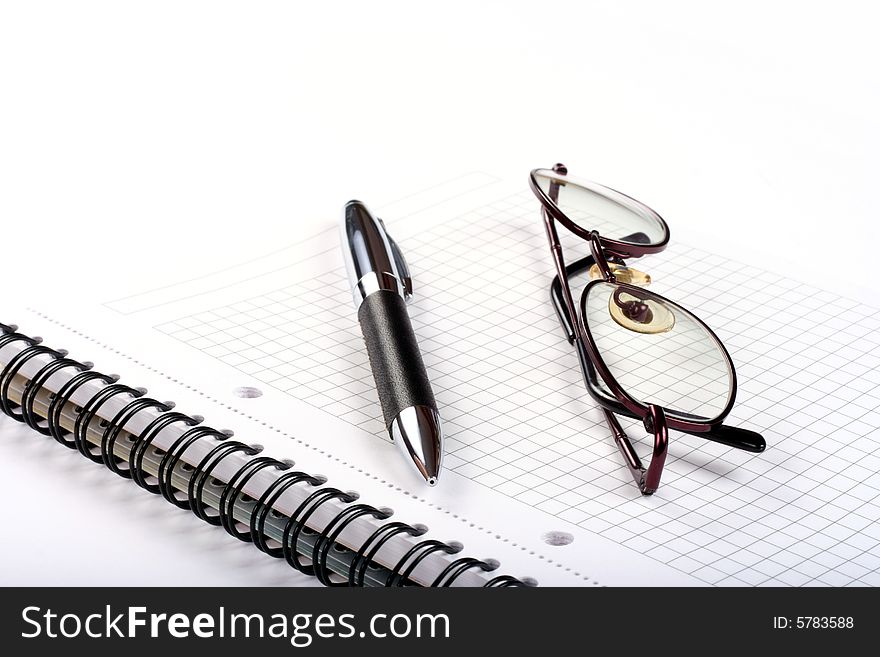 Notepad with eyeglasses and pen isolated