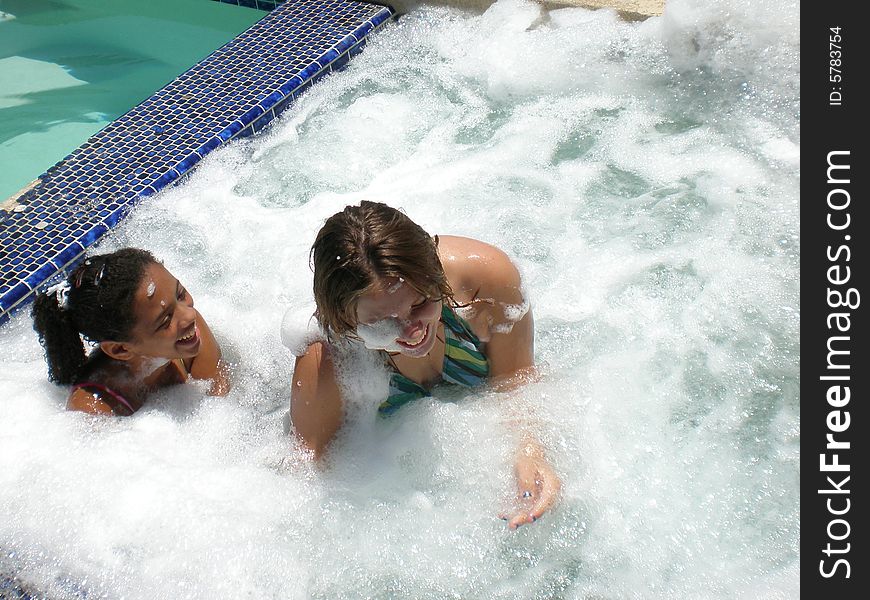 A picture of two friends who are best friends playing and splashing each other in a jacuzzi. A picture of two friends who are best friends playing and splashing each other in a jacuzzi.