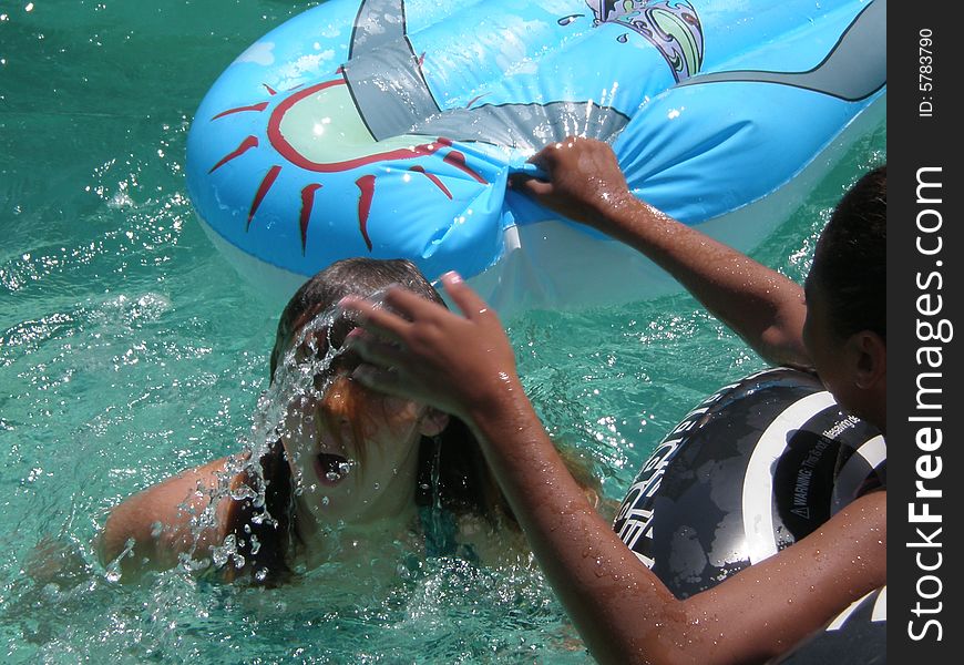 A picture of two teen girls playing in the swimming pool. A picture of two teen girls playing in the swimming pool.