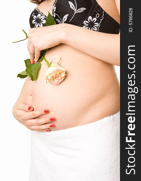 Pregnant woman holding her belly and flower