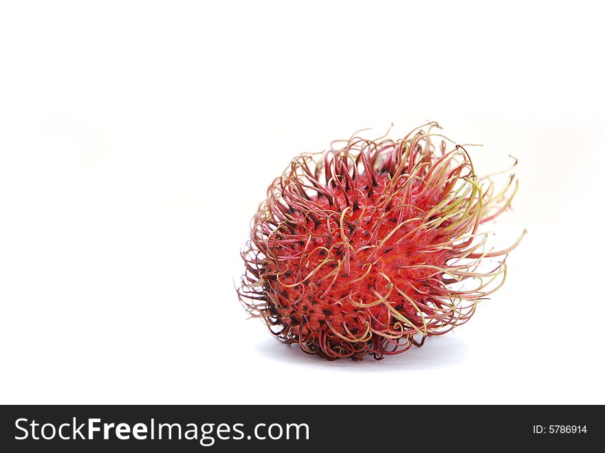 Red, spiky, whole rambutan fruit (Nephelium lappaceum), isolated on white background.