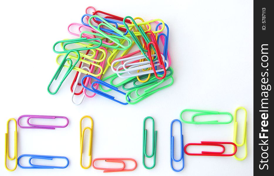 Spelling CLIP with paper clips on white background.