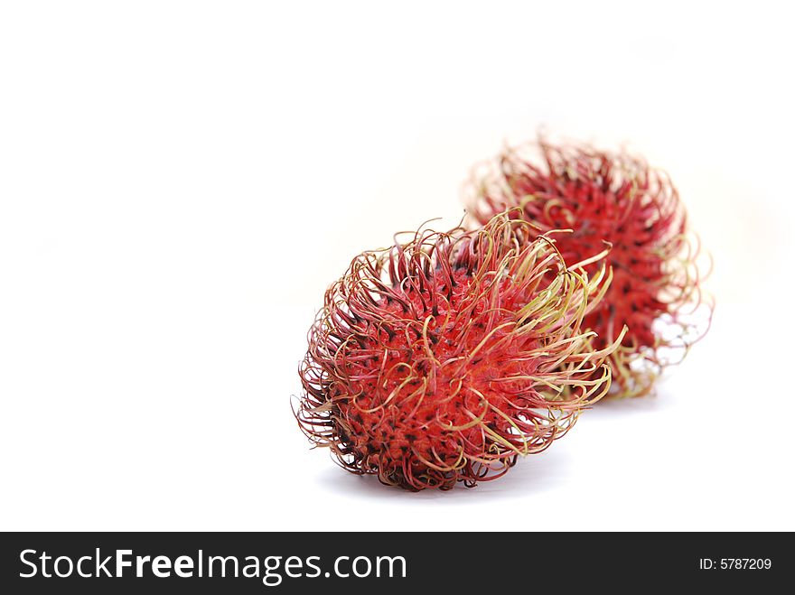 Rambutan fruits (Nephelium lappaceum), isolated on white background, front one sharp, background one blurred