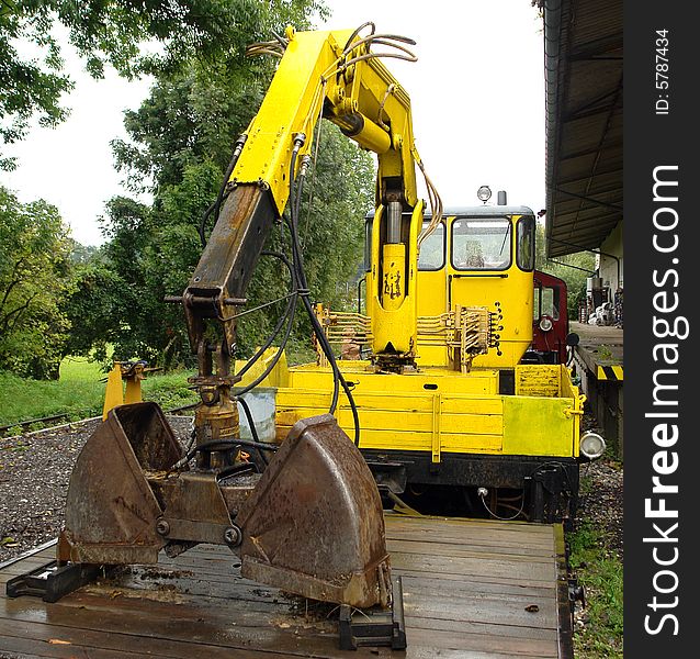 Yellow Railway dredge on a platform at small railway station in Bavaria.