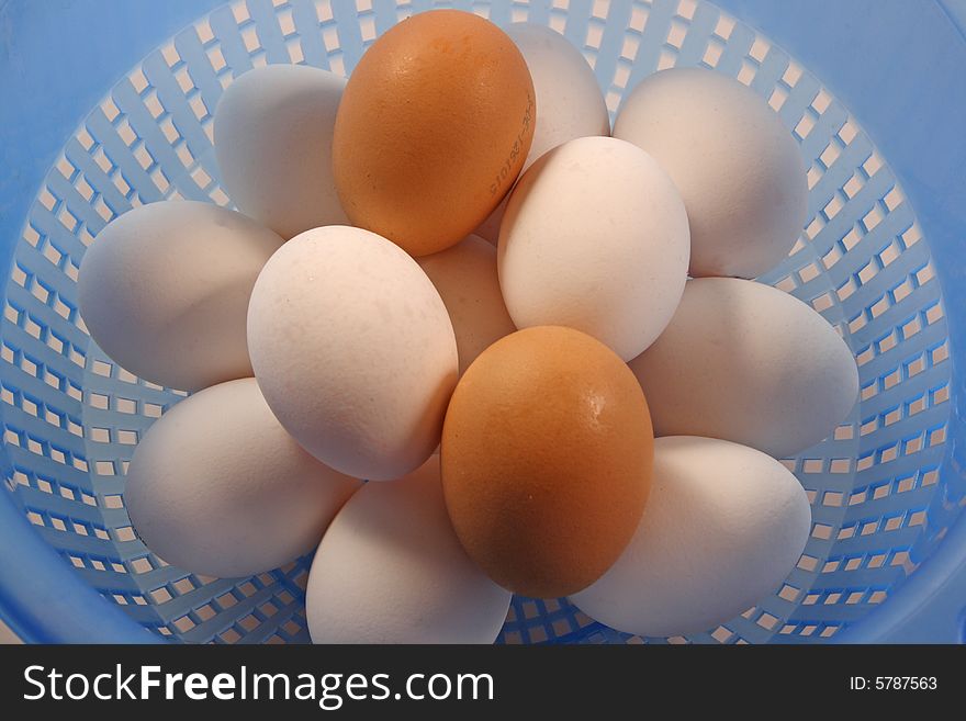 Brown and white eggs in sieve