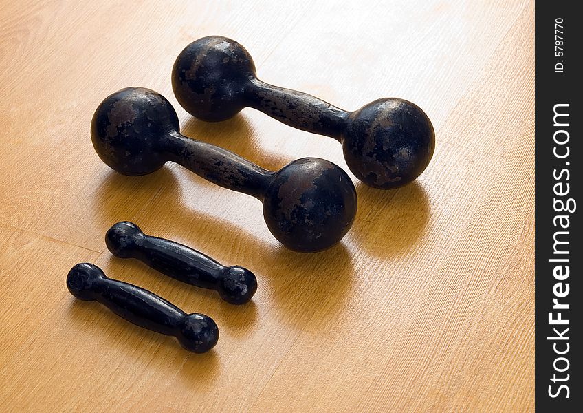 Greater and small dumbbells on a floor of a sports hall