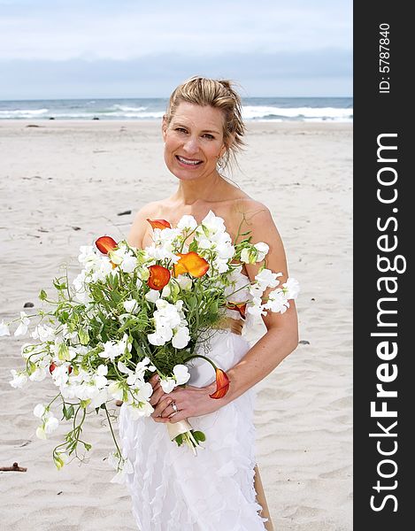 Pretty Bride on the beach holding her bouquet. Pretty Bride on the beach holding her bouquet