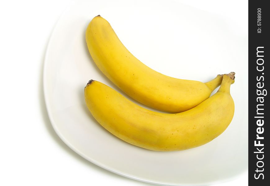 A bunch of fresh bananas on white plate and isolated on white background. A bunch of fresh bananas on white plate and isolated on white background
