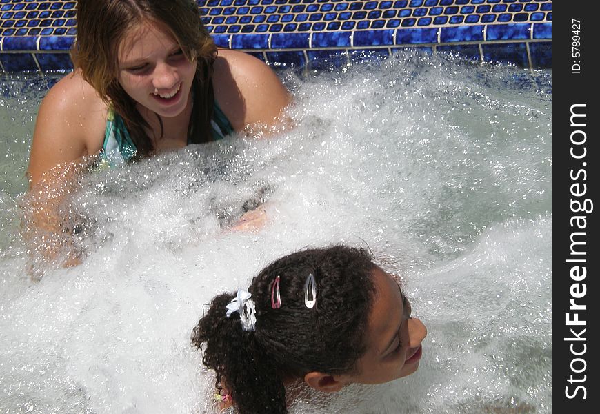 A picture of two girls who are best friends talking and playing in jacuzzi bubbles. A picture of two girls who are best friends talking and playing in jacuzzi bubbles.