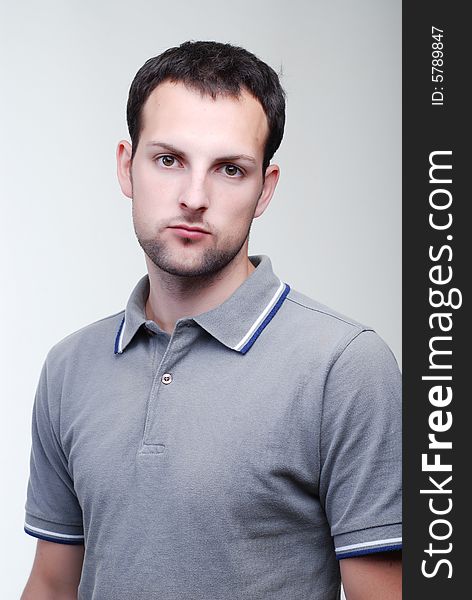 Portrait of young fellow dressed in a grey sport shirt. Portrait of young fellow dressed in a grey sport shirt