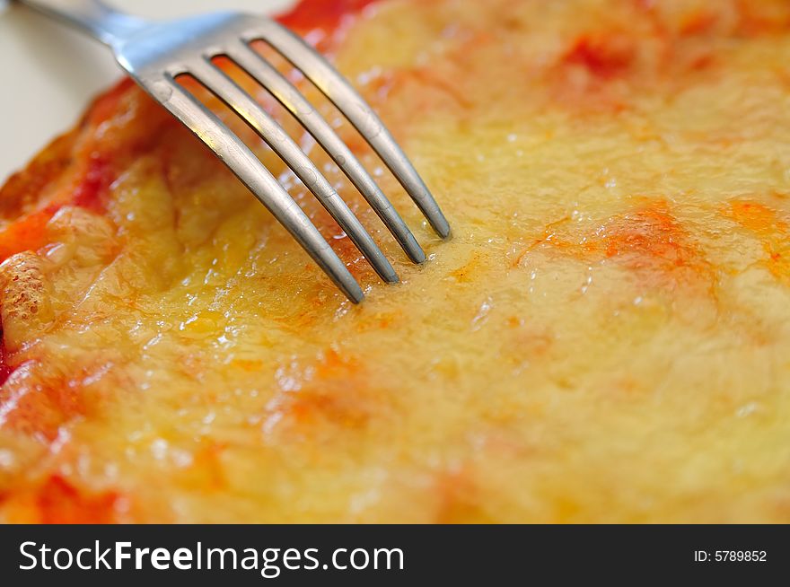 Close shot about a little tomato and mozzarella cheese pizza, with a fork. Close shot about a little tomato and mozzarella cheese pizza, with a fork.