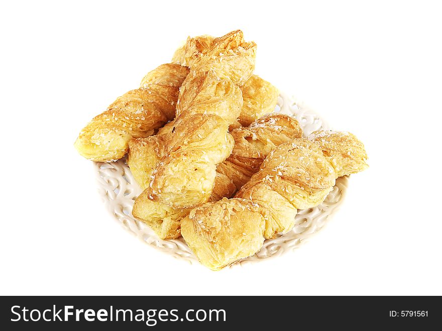 Fresh puff rolls on a plate on a white background