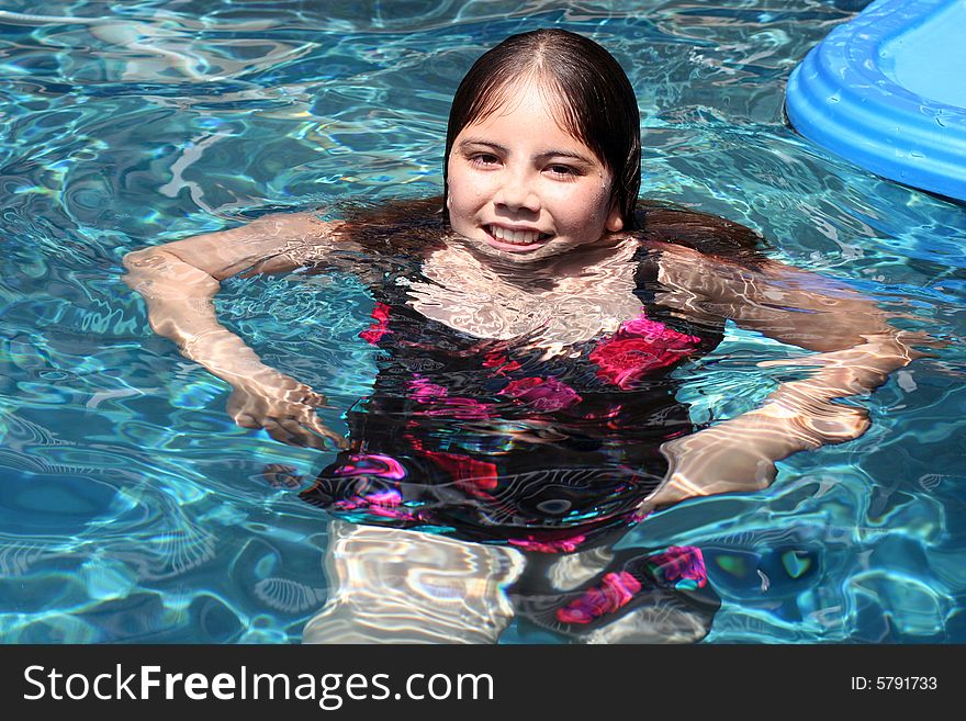 Young girl of 12 having fun in a swimming pool.  She has brown eyes and hair and is of Asian and Caucasian background, multi-racial. Young girl of 12 having fun in a swimming pool.  She has brown eyes and hair and is of Asian and Caucasian background, multi-racial.