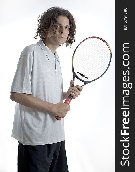 A tennis player holding a racket and looking timidly at the camera. Vertically framed shot. A tennis player holding a racket and looking timidly at the camera. Vertically framed shot.